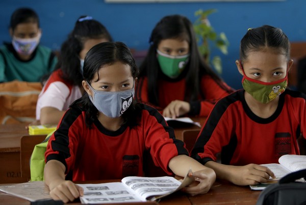 Students wear masks to prevent respiratory problems in Palembang, South Sumatra, Indonesia, Friday, Sept. 18, 2015. Slash-and-burn practices destroy huge areas of Indonesian forest during dry season causing forest fires that are spreading choking smoke and polluted air across parts of western Indonesia and neighboring countries. (AP Photo/Tatan Syuflana)