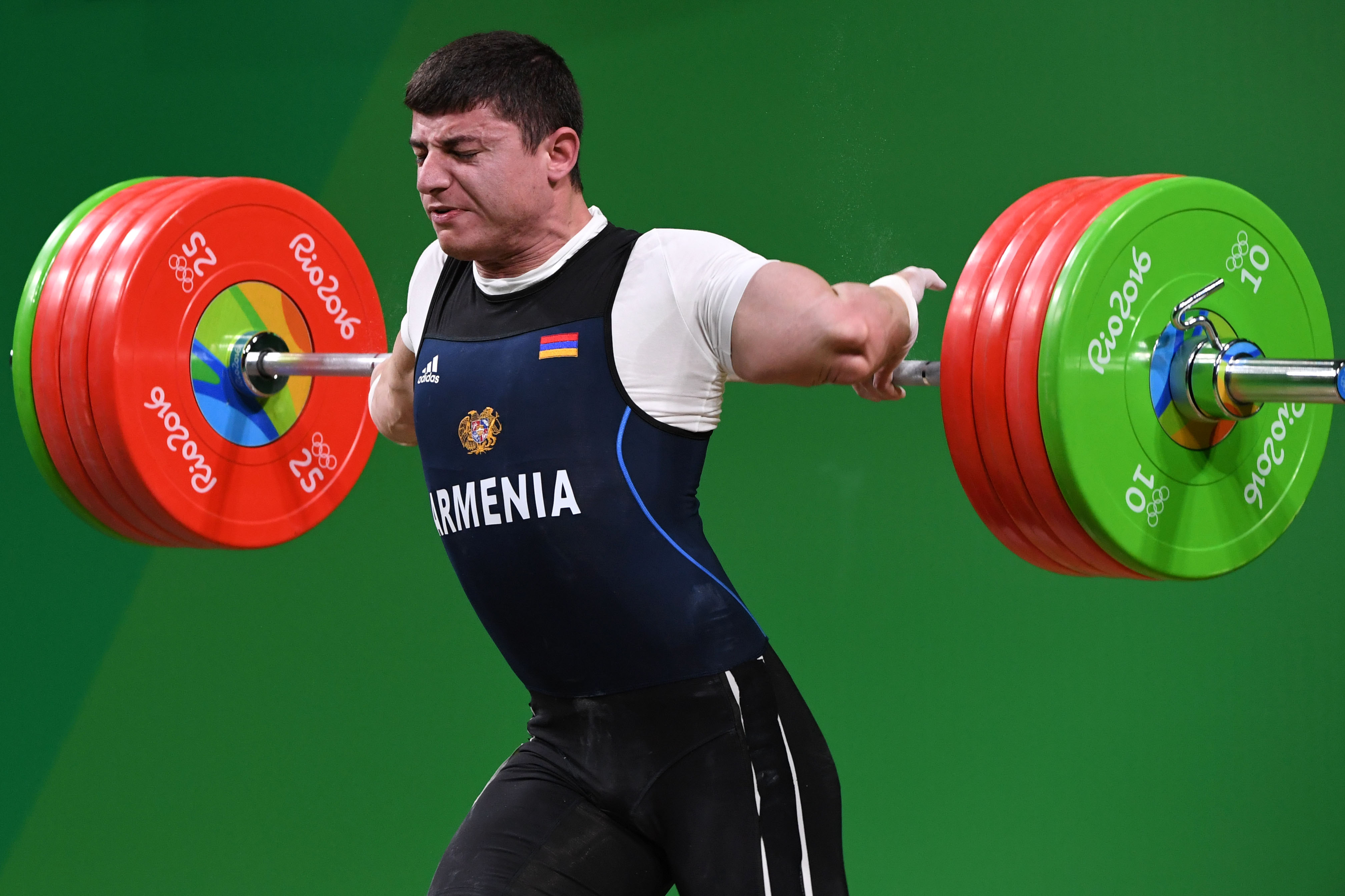 TOPSHOT - Armenia's Andranik Karapetyan sustains an injury while competing during the Men's 77kg weightlifting competition at the Rio 2016 Olympic Games in Rio de Janeiro on August 10, 2016. / AFP PHOTO / GOH Chai Hin